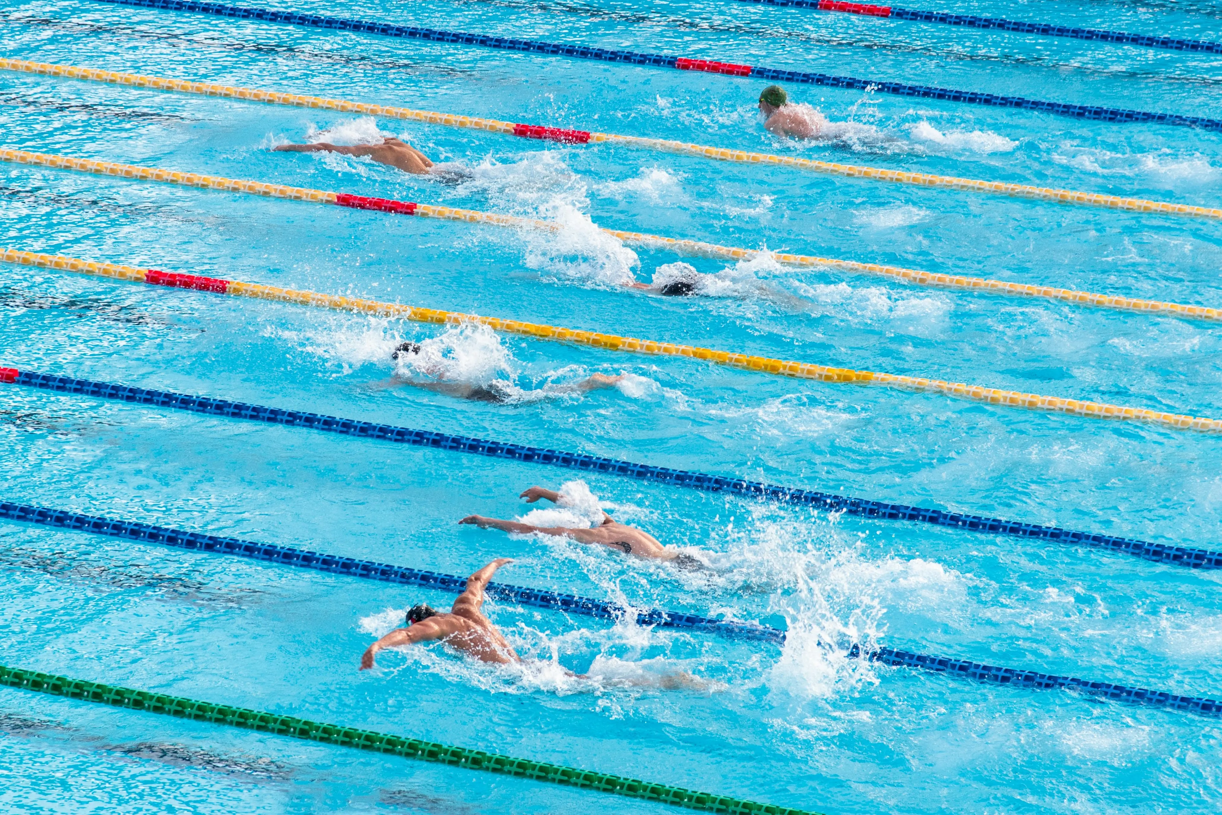 Swimmer mid-stroke in a pool lane, water splashing