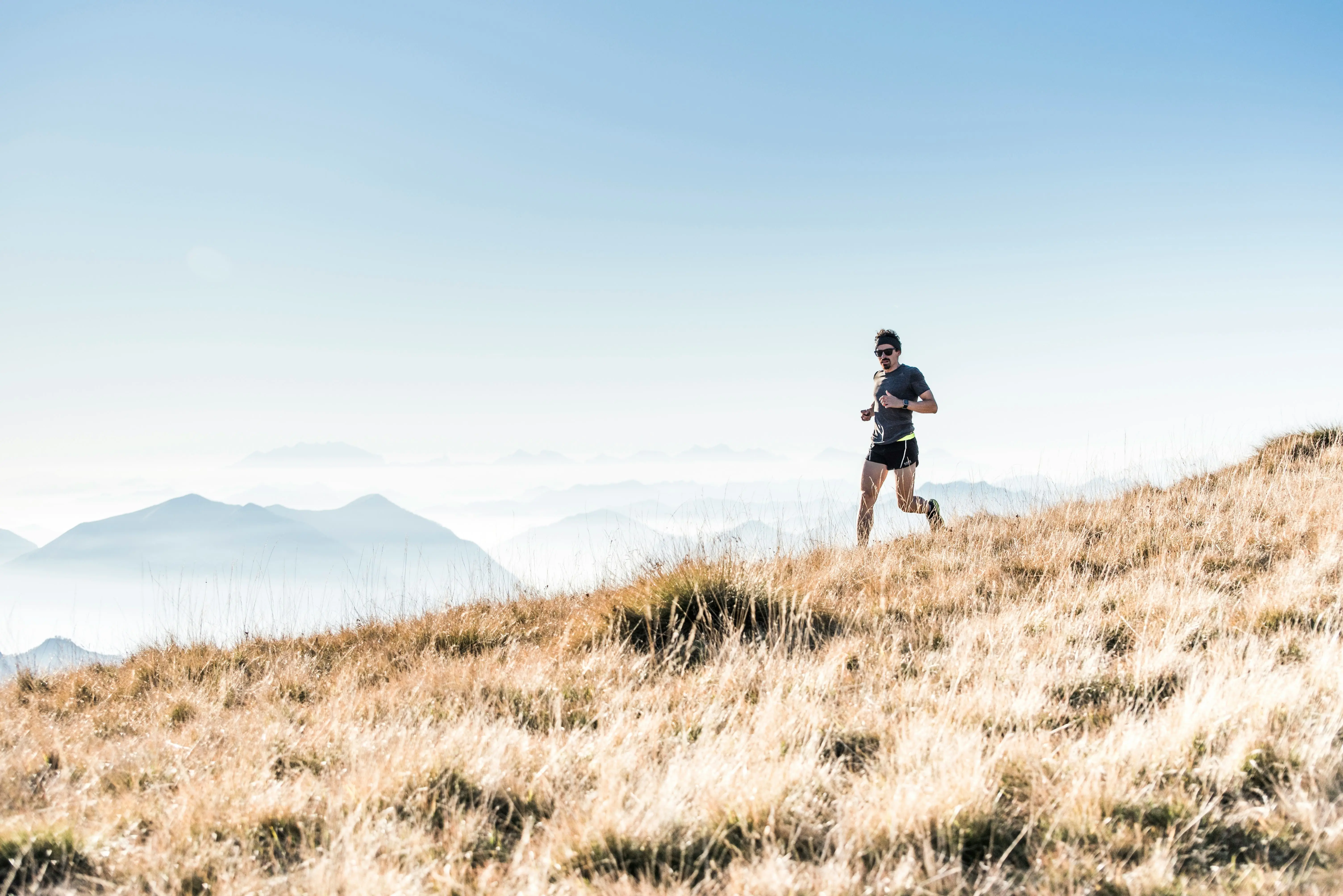 Trail runner on a mountain path surrounded by forest